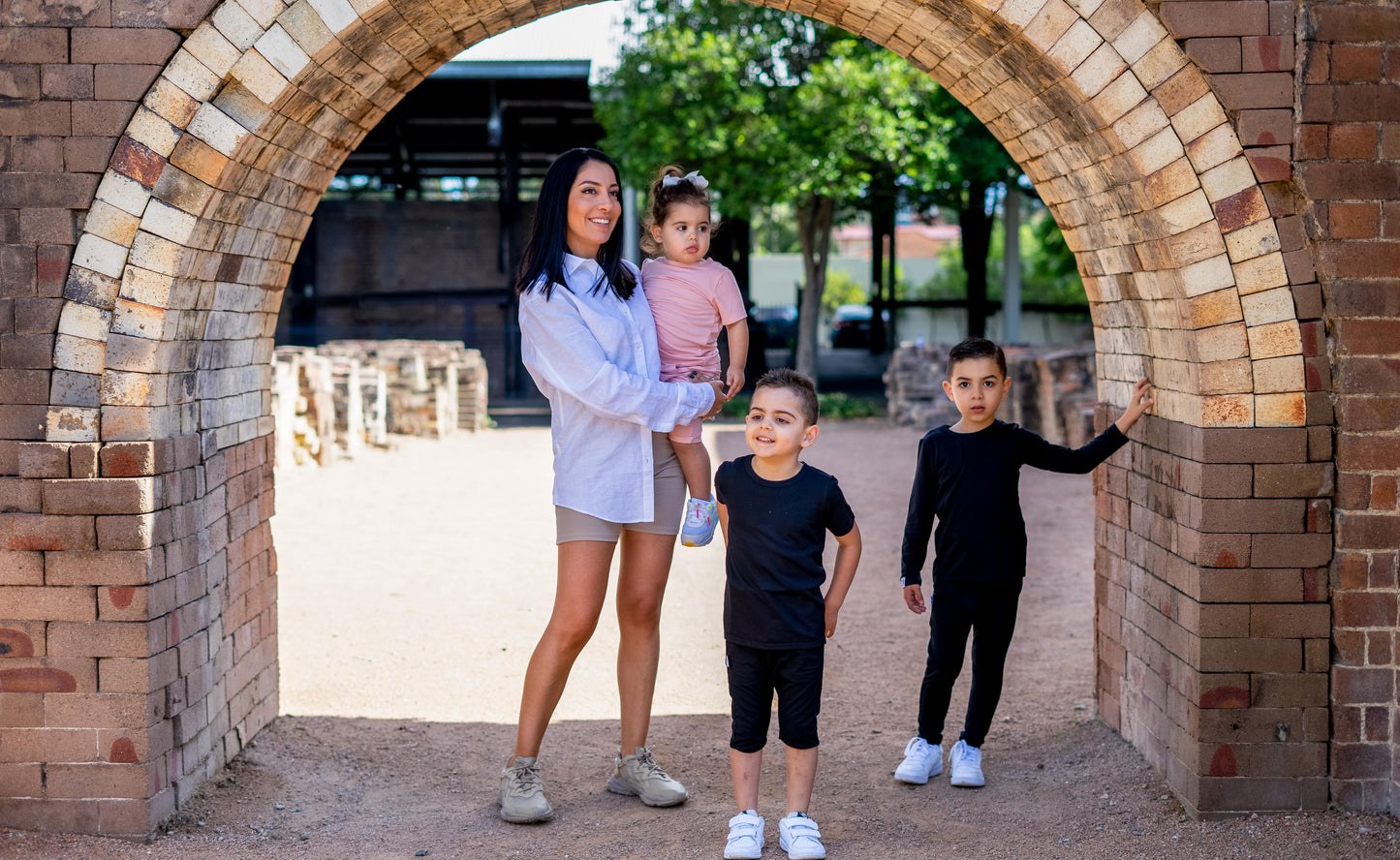 Woman with three children standing under a brick archway
