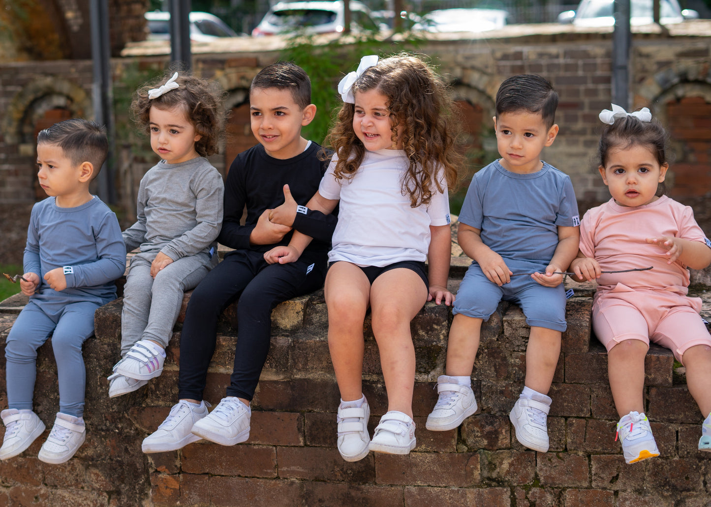Children sitting on a brick wall outdoors