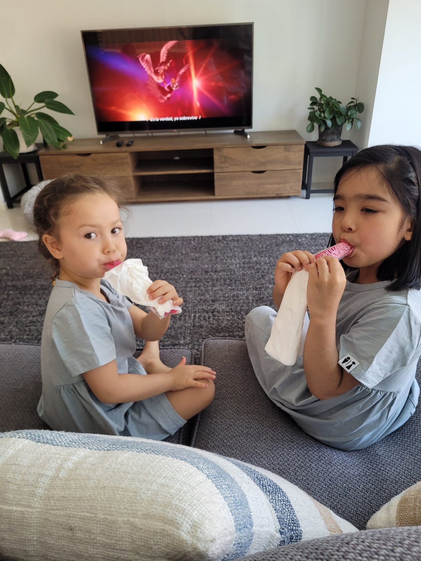 two girls wearing summer dresses and eating ice-cream