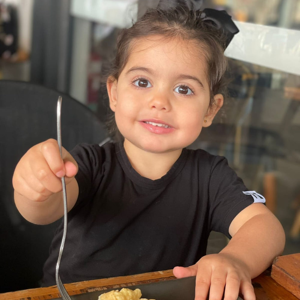 Child eating brunch in a bamboo Baby Todd & Co. tee