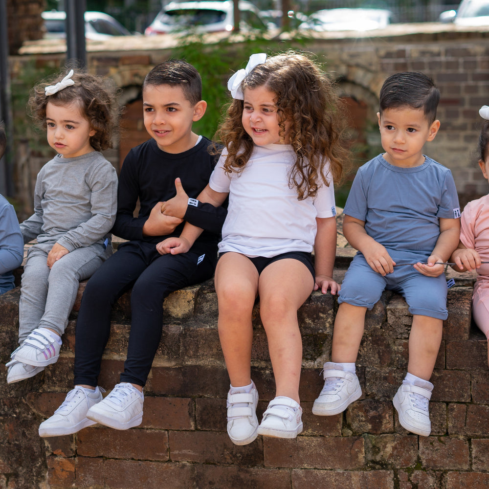 Children sitting on a brick wall outdoors
